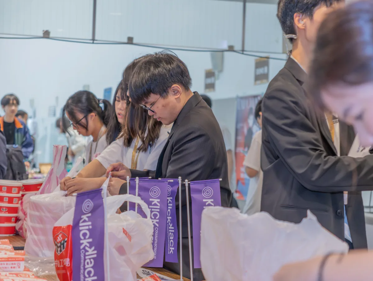 SITCON 2026 工作人員分裝餐點，桌上插著贊助商小旗